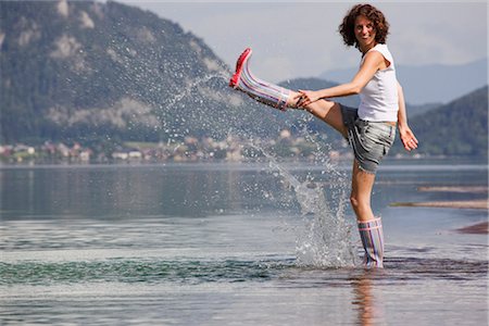 Woman Kicking in Shallow Water,  Fuschlsee, Salzburg, Austria Stock Photo - Rights-Managed, Code: 700-03333139