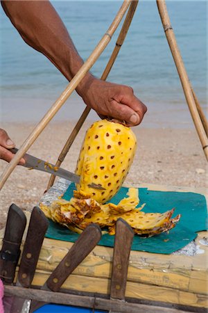 Man Peeling Pineapple, Ko Samui, Thailand Stock Photo - Rights-Managed, Code: 700-03403926