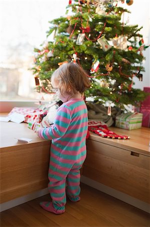 sleeper - Vue de Little Girl Unwrapping cadeaux à côté du sapin de Noël de retour Photographie de stock - Rights-Managed, Code: 700-03439553