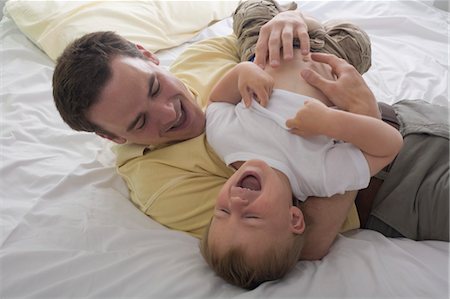 parents tickling children - Father and Son Playing on Bed Stock Photo - Rights-Managed, Code: 700-03445840