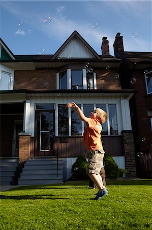 Boy Chasing Bubbles on Front Lawn, Toronto, Ontario, Canada Stock Photo - Rights-Managed, Code: 700-03520601