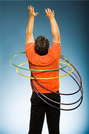 shape toys - Man Hula Hooping With Several Hula Hoops Stock Photo - Rights-Managed, Code: 700-03638640