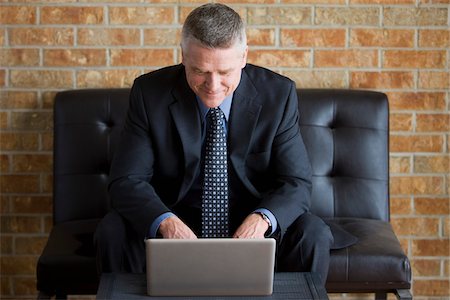 Businessman Using Laptop in Reception Area Stock Photo - Rights-Managed, Code: 700-03777997