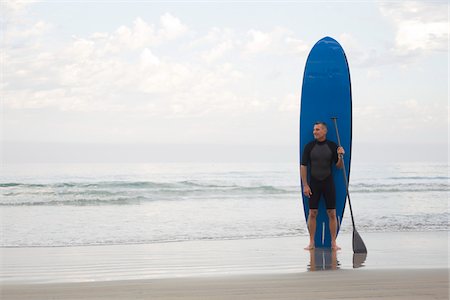 Man with Surfboard and Paddle on Beach Stock Photo - Rights-Managed, Code: 700-03787179