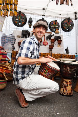 Man Playing Drum at Booth in Market Stock Photo - Rights-Managed, Code: 700-03865237