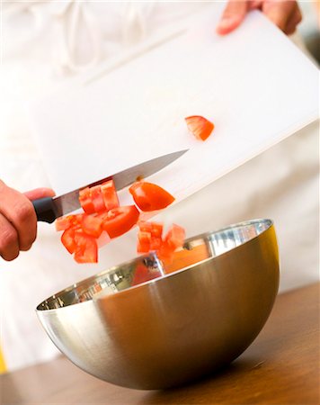 Putting the diced tomato into a bowl Foto de stock - Con derechos protegidos, Código: 825-05814861