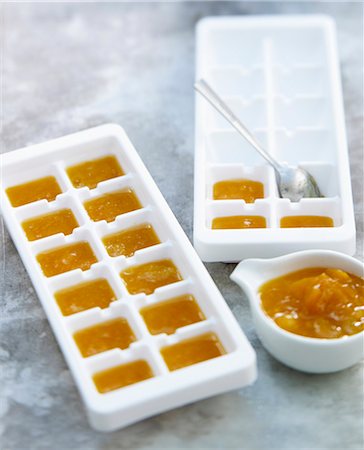 Filling the ice cube trays with stewed apricot puree Stock Photo - Rights-Managed, Code: 825-06816797