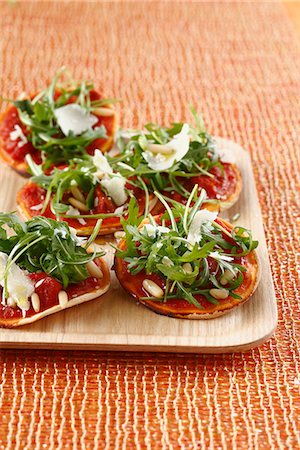 simsearch:825-07522085,k - Rocket lettuce and confit tomato mini pizzas Stock Photo - Rights-Managed, Code: 825-06817616