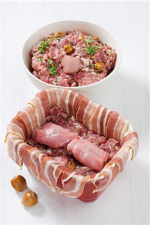 simsearch:652-03804848,k - Coating the terrine with steaky bacon and filling the terrine with the rabbit and hazelnut preparation Stock Photo - Rights-Managed, Code: 825-07076909
