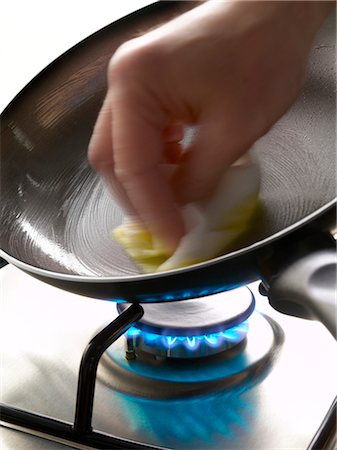 Greasing a frying pan on the gas cooker Stock Photo - Rights-Managed, Code: 825-03628815