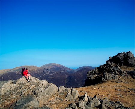 Tourists sitting on a rock formation, Mountains of Mourne, County Down, Northern Ireland Stock Photo - Rights-Managed, Code: 832-03358895