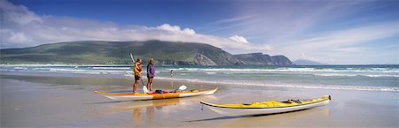 Keel Bay, Achill Island, County Mayo, Ireland; Two People Standing Near Canoes Stock Photo - Rights-Managed, Code: 832-03639368