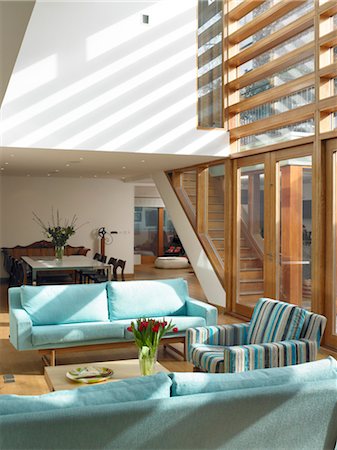 Modern double-height sunlit room with pale blue seating and wooden floor. Architects: STUDIO BEDNARSKI LTD Stock Photo - Rights-Managed, Code: 845-05837806