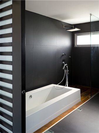 Modern minimal bathroom with dark walls, bathtub and high-level window Stock Photo - Rights-Managed, Code: 845-05837854