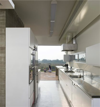 Two children sit on kitchen terrace of house designed by Weinstein Vaadia Architects, Hofit, Israel. Hofit House, Israel. Architects: Weinstein Vaadia Architects Stock Photo - Rights-Managed, Code: 845-05837852