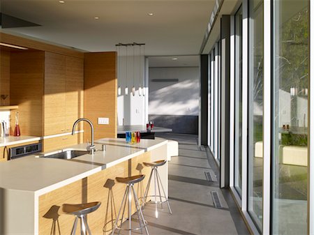 Bar stools at breakfast bar in sunlit kitchen, Briarcrest House, Beverly Hills, California, USA. Architects: SPF Architects Stock Photo - Rights-Managed, Code: 845-05837900