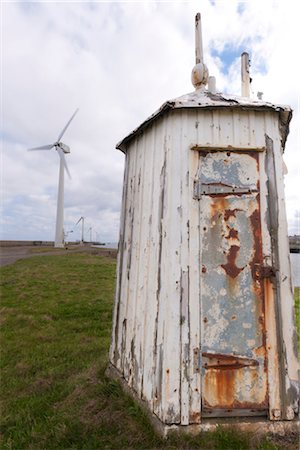 simsearch:845-05838406,k - View of delapidated wooden shed with peeling paint and rusting metal door, with several wind turbines in the distance, Port of Blyth, Northumberland. Stock Photo - Rights-Managed, Code: 845-05838337