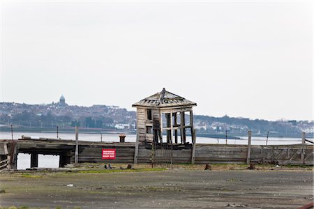 simsearch:845-05838406,k - Derelict wooden building in the docks by the side of the River Mersey, Liverpool, with New Brighton in the background. Stock Photo - Rights-Managed, Code: 845-05838365