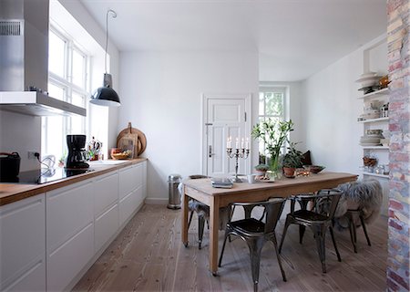 Open plan kitchen with wall shelving and window seat. Photographie de stock - Rights-Managed, Code: 845-07561472