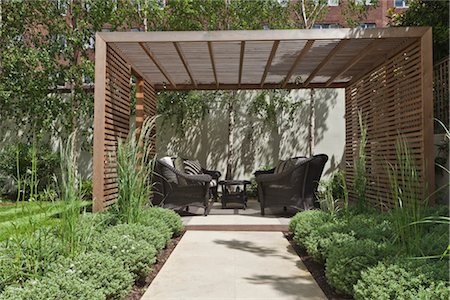 Slatted cedar pavilion on the right side of the lawn on the upper level of the garden. Silver birches along the boundary wall to the rear. sawn sandstone path lined with hebe and grasses. Architects: Modular Stock Photo - Rights-Managed, Code: 845-03777658