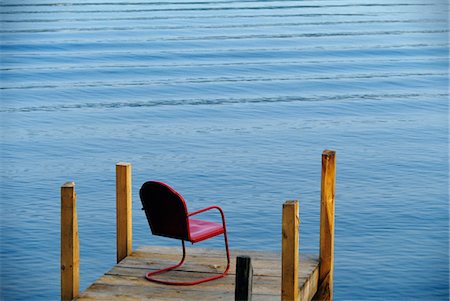 SINGLE RED METAL CHAIR ON DOCK LAKE GEORGE NEW YORK Stock Photo - Rights-Managed, Code: 846-05645789