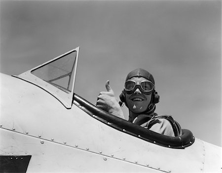 simsearch:846-05645924,k - 1940s SMILING ARMY AIR CORPS PILOT IN OPEN COCKPIT WEARING A LEATHER FLYING HELMET GIVING A THUMBS-UP SIGN Stock Photo - Rights-Managed, Code: 846-05645851