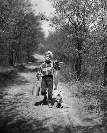 retro fishing - 1950s BOY BEAGLE PUPPY WALKING DOWN COUNTRY ROAD WHISTLING CARRYING FISHING POLE PAIL FISH Stock Photo - Rights-Managed, Code: 846-05645865