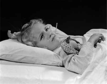 simsearch:846-05645854,k - 1940s SICK LITTLE GIRL LYING IN BED WITH DOLL UNDER ARM & THERMOMETER IN MOUTH Stock Photo - Rights-Managed, Code: 846-05645862