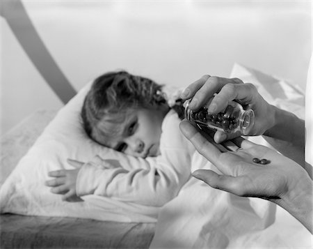 simsearch:846-05645854,k - 1960s DISTRESSED LITTLE GIRL IN BED MOTHERS HANDS POURING PILLS FROM BOTTLE Stock Photo - Rights-Managed, Code: 846-05645893