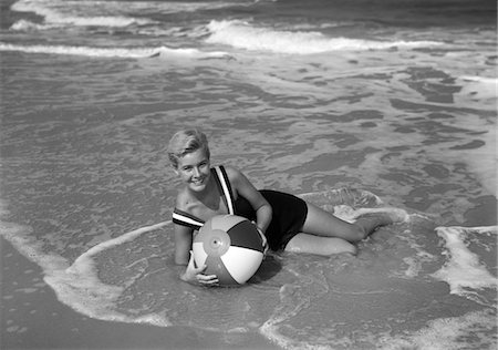 1960s WOMAN IN BATHING SUIT LYING IN THE SURF HOLDING A BEACH BALL SMILING OUTDOOR Stock Photo - Rights-Managed, Code: 846-05646101