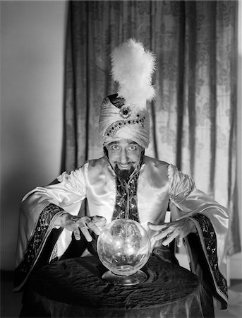 simsearch:400-04279469,k - 1950s PORTRAIT MAN SOOTHSAYER SWAMI FORTUNE TELLER WEARING ROBE AND FEATHER IN TURBAN GAZING OVER CRYSTAL BALL Stock Photo - Rights-Managed, Code: 846-05646208