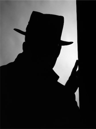 silhouette black and white - 1950s SILHOUETTE OF MAN INTRUDER IN HAT AND COAT WITH ONE HAND ON A DOOR FRAME Stock Photo - Rights-Managed, Code: 846-05646217
