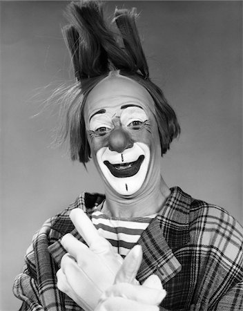 1960s SMILING CLOWN WITH WHITE GLOVED CROSSED HANDS AND HAIR STANDING ON END LOOKING AT CAMERA Stock Photo - Rights-Managed, Code: 846-05646224