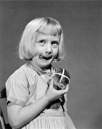 1950s - 1960s BLONDE GIRL LICKING HER LIPS EATING HOT CROSS BUN Stock Photo - Rights-Managed, Code: 846-05646371