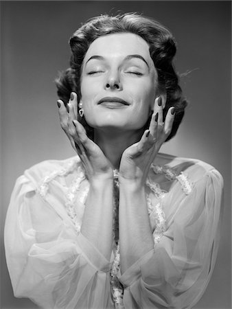 experiencing - 1950s WOMAN WEARING PEIGNOIR WITH EYES CLOSED HANDS HELD NEAR FACE ECSTATIC FACIAL EXPRESSION Stock Photo - Rights-Managed, Code: 846-05646397