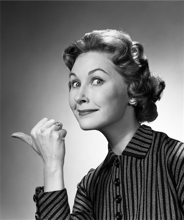 simsearch:400-04790442,k - 1960s PORTRAIT OF PROUD SMILING WOMAN MAKING GO AWAY GESTURE WITH THUMB STUDIO Stock Photo - Rights-Managed, Code: 846-05646409
