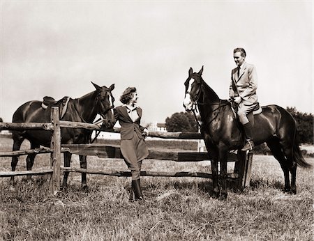 sports in the 1940s - 1930s - 1940s COUPLE IN RIDING GEAR MAN RIDING HORSE WOMAN STANDING BY WOODEN FENCE Stock Photo - Rights-Managed, Code: 846-05646453