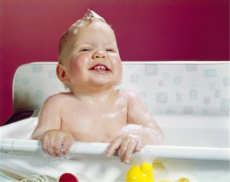 1960s SMILING BABY HOLDING ON TO SIDE OF INFANT BATH Stock Photo - Rights-Managed, Code: 846-05646694