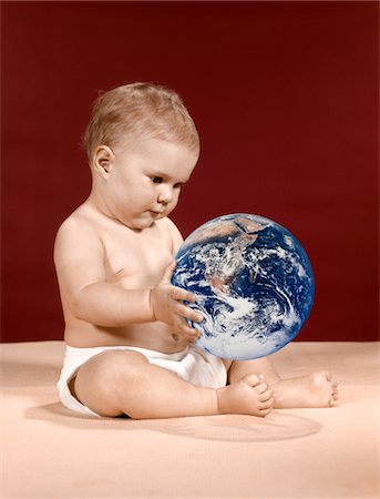 simsearch:846-05645898,k - 1960s SYMBOLIC ECOLOGY SERIOUS BABY WEARING CLOTH DIAPERS SITTING HOLDING LOOKING AT THE EARTH Stock Photo - Rights-Managed, Code: 846-05646690