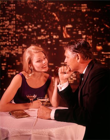 entertainment and restaurant - 1960s - 1970s SMILING ROMANTIC COUPLE MATURE MAN BLOND WOMAN IN FORMAL EVENING DRESS IN A NIGHTCLUB DRINKING CHAMPAGNE Stock Photo - Rights-Managed, Code: 846-05646926