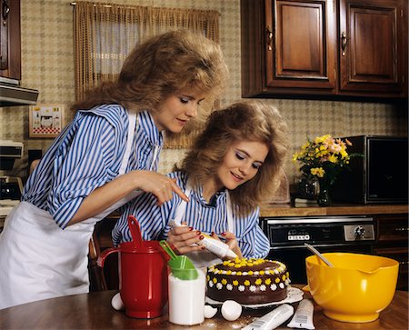 1970s MOTHER DAUGHTER DRESSED ALIKE DECORATING CAKE Stock Photo - Rights-Managed, Code: 846-05647043