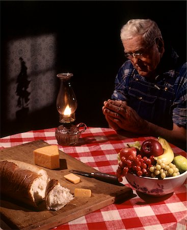 simsearch:846-03164224,k - 1960s SENIOR ELDERLY MAN PRAYING SAYING PRAYER THANKSGIVING TABLE LAMP FRUIT BREAD CHEESE RELIGION Stock Photo - Rights-Managed, Code: 846-05647359