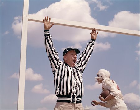 simsearch:846-05647924,k - 1960s FOOTBALL REFEREE HOLDING UP ARMS AT GOAL POST AS PLAYER MAKES TOUCHDOWN Stock Photo - Rights-Managed, Code: 846-05647469