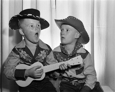 1950s 2 JUVENILE BOYS IN COWBOY HAT & SHIRTS PLAYING UKULELE & SINGING MOUTH OPEN WIDE Stock Photo - Rights-Managed, Code: 846-05647641