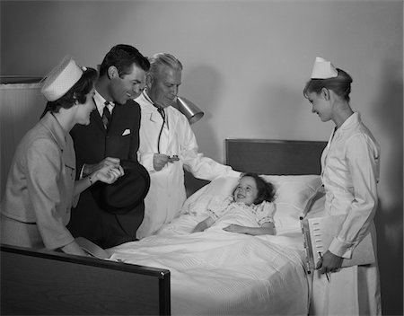 simsearch:846-05647696,k - 1960s MAN DOCTOR WOMAN NURSE MOTHER FATHER SEEING VISITING SMILING LITTLE GIRL PATIENT IN HOSPITAL BED Stock Photo - Rights-Managed, Code: 846-05647692