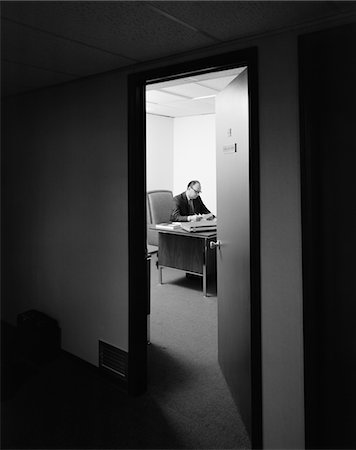simsearch:846-02795767,k - 1960s - 1970s EXECUTIVE BUSINESSMAN AT DESK SEEN WORKING LATE THROUGH DOOR AJAR Stock Photo - Rights-Managed, Code: 846-05647778
