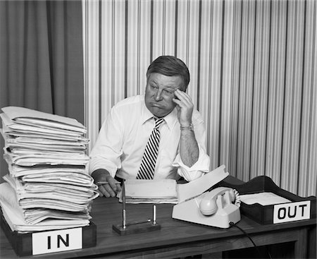 simsearch:846-02795767,k - 1970s CONCERNED BUSINESSMAN STARING LARGE PILE PAPERWORK IN IN-BOX Stock Photo - Rights-Managed, Code: 846-05647784