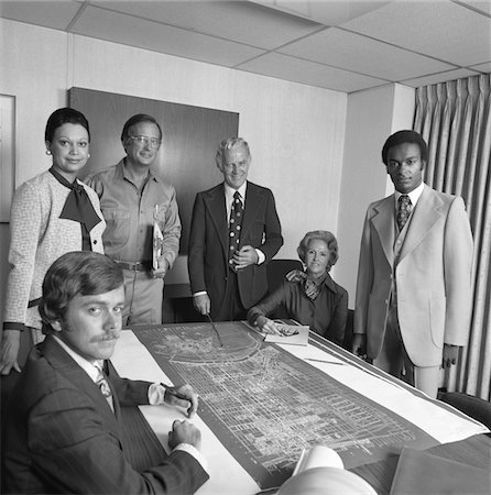 simsearch:846-05648290,k - 1970s PORTRAIT 6 BUSINESS PEOPLE MEN & WOMEN AROUND TABLE WITH BLUEPRINTS Stock Photo - Rights-Managed, Code: 846-05647787