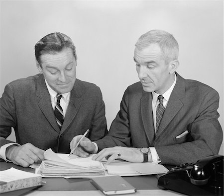 simsearch:846-02795767,k - 1960s TWO BUSINESSMEN SEATED AT DESK LOOKING AT FILE FOLDERS Stock Photo - Rights-Managed, Code: 846-05647794