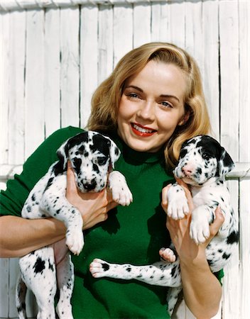 1950s PORTRAIT SMILING TEEN GIRL WEARING GREEN SWEATER HOLDING TWO DALMATIAN PUPPIES Stock Photo - Rights-Managed, Code: 846-05647837